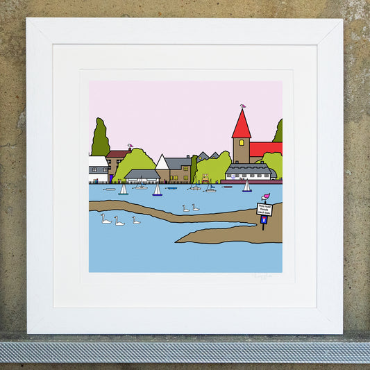 Giclee original artwork print in a white mounted frame. The print is of Bosham, with a pale pink sky. The church is in the distance with a red roof and a small pink winged seagull is perched on the top. There are small buildingsof different shapes and sizes amongst trees. In front of the buildings is water with small boats and swans swimming across. In the sand there is a sign that says this road floods each tide with a small pinked winged seagull stood on top.
