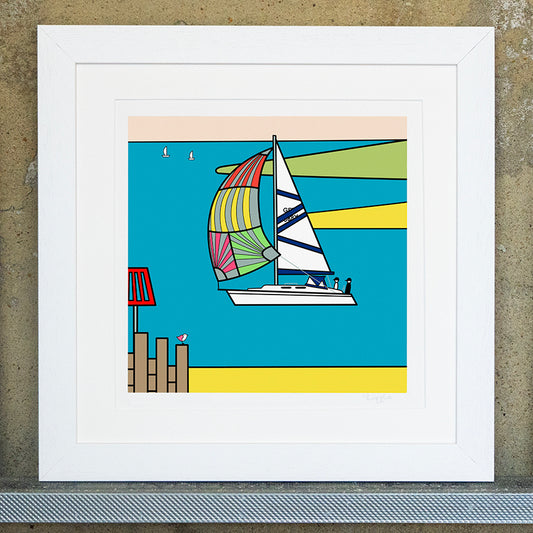 Giclee original artwork print in a white mounted frame. A sailing boat is going across the water with two small figures in the back. The water is a bright blue with a pale peach sky, the land and sand is yellow and green that meets the water. In the distance are two small sailing boats in the water. There is sand at the bottom of the print with groynes to the left and a red warning post. on top of the groyne is perched a small pink winged seagull looking out.