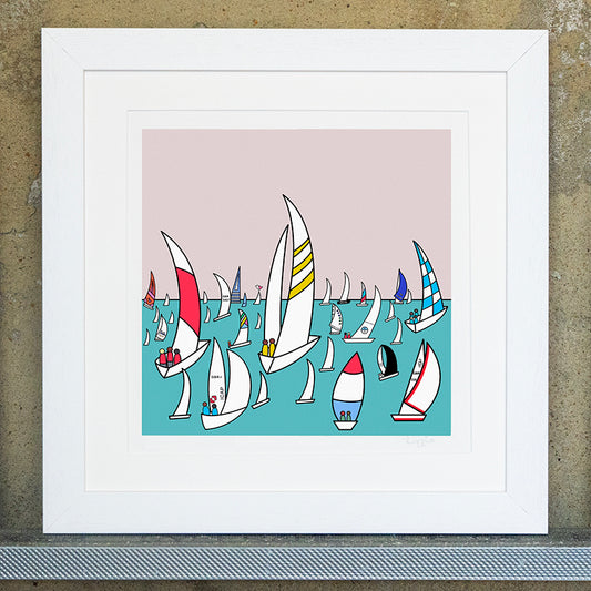 Giclee original artwork print in a white mounted frame. Multiple sailing racing boats are in the sea, all different sizes with different patterns and colours in the sails. The sea is a aqua colour with a pale pink sky. The original print is called Island Racing.