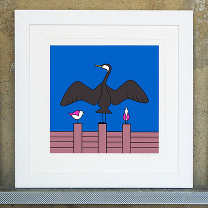 Giclee original artwork print in a white mounted frame. A groyne has a cormorant with it's wings spread out. Either side are two pink winged seagulls also perched on the groyne, one is looking up at the wing of the cormorant and the other to the side. the sky is bright blue.