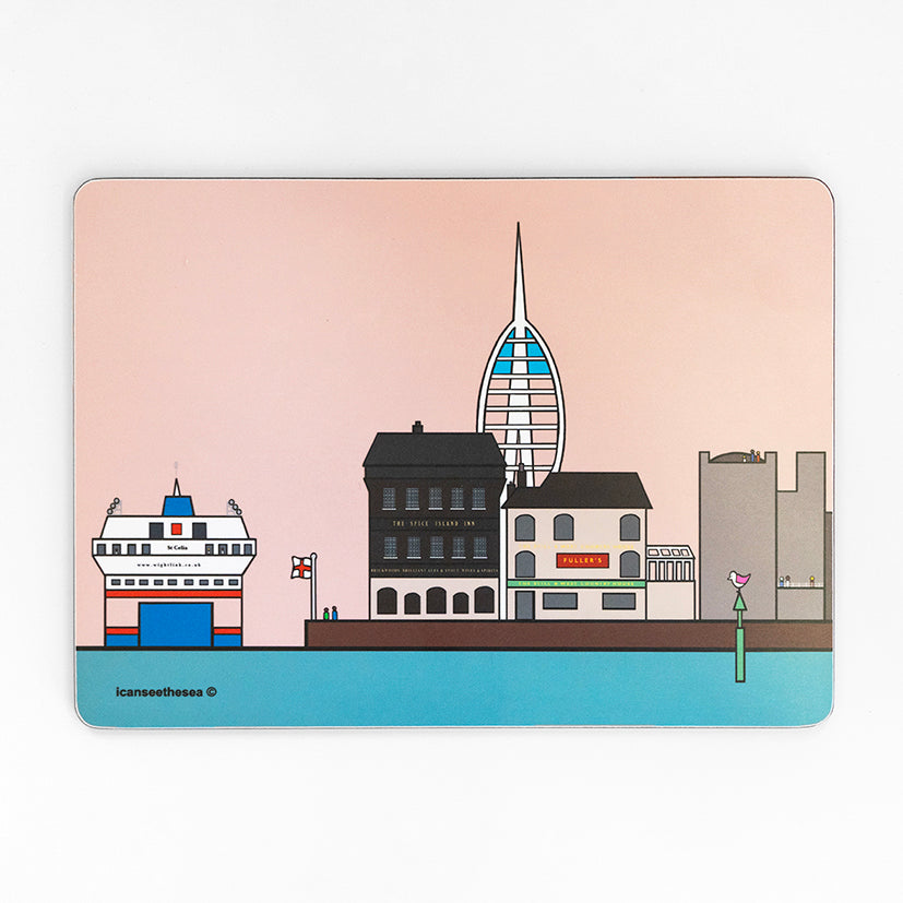 A placemat of a painting of the isle of wight ferry in Old Portsmouth. The sky is pastel pink with a blue sea. On the horizon is the round tower, pubs, the spinnaker tower in the distance and the ferry in the sea. Two small figures can be seen near the walls edge looking out and standing by an england flag. On a green beach safety maker, sits a pink winged seagull looking out.