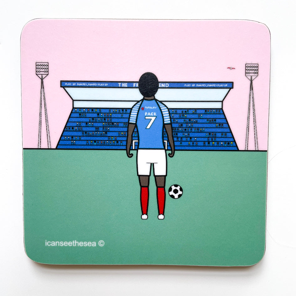 A coaster of a painting of fratton park. A green patch of grass stands a figure with bright red socks, white shorts and blue shirt with a football by his right foot facing the crowd and stadium. In the distance are small figures all wearing blue in a stadium that has play up pompey, pompey play up at the top. Two enormous lights are on stands either side and a pink winged seagull is flying in the sky.