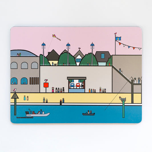 A placemat of a painting of Hotwalls in Old Portsmouth. The beach, steps and view points have lots of figures in different colours. Behind the wall you can see trees and the tops of buildings, the sky is pale pink and the blue sea has small fishing boats. A kite flys in the sky, a figure is fishing and there are pink winged seagulls on tops of the buildings.