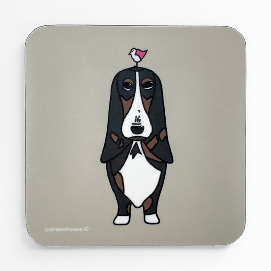 coaster with a long eared brown and black dog with a small pink wing seagull on the dogs head the coaster has a pale grey beige background