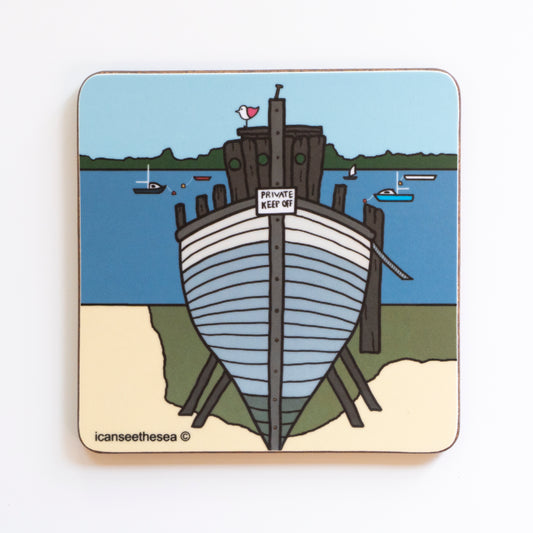 A coaster of a painting of a small wooden boat facing forwards with a sign that says private keep off. The boat is on a beach and grass with stilts holding it up, on top of the boat sits a pink winged seagull looking out. In the background is blue sea with small fishing and sailing boats with buoys in yellow and red. In the far distance in green on the horizon representing trees, hedges and the landscape. The sky is pale blue.