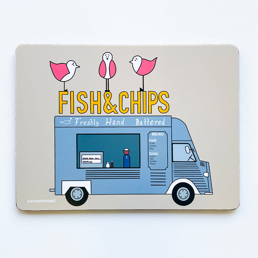 A beige placemat of a painting of a fish & chips van. The van is a blue grey parked sideways with a sign that says freshly hand battered and a menu. A figure is inside the van with a glass box with fish and pies inside. on top of the van is a sign that says Fish & Chips in golden yellow with three pink winged seagulls sat on top looking in different directions.