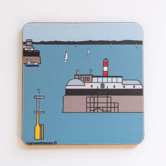 A coaster of a painting of the solent forts. A blue sea with pale blue sky has two forts in the ocean. In the sea are white sailing boats in the distance. The two forts have england flags, arched windows and red and white buildings. In the distance is the landscape and a yellow seamarker is in the sea with a pink winged seagull perched on top.