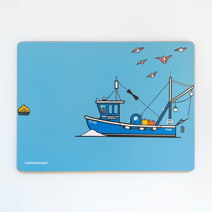 A placemat of a painting of a fishing boat. The background is blue with a bright blue fishing boat with a small figure at the front. The boat has yellow and red tubs full of fish, buoys, nets, floats and poles with ropes. Above the boat are five pink winged seagulls flying. The boat has numbers, and a white wave at the front showing its movement in the water.